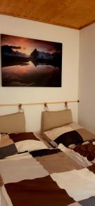 two beds in a room with a painting on the wall at Dachstein Adventure in Obertraun