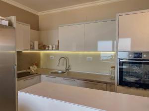 a kitchen with white cabinets and a sink at Apartments Piano in Utjeha