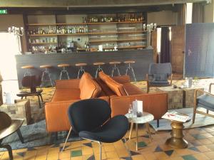 ein Zimmer mit einem Sofa und Stühlen sowie einer Bar in der Unterkunft Fletcher Hotel-Restaurant Kasteel Coevorden in Coevorden