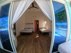 a room with two beds and a window at El Embrujo Tintipan in Tintipan Island