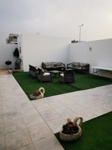 a living room with couches and chairs and grass at فيلا فيوتشر in Al Fayşalīyah