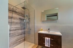 a bathroom with a shower with a sink and a mirror at Dewin Bach - Luxury Lodge, Hot Tub, Close to Beach in Penally +38 photos