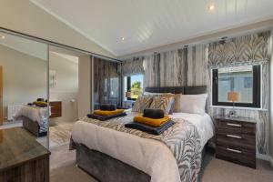 a bedroom with a large bed with yellow pillows on it at Dewin Bach - Luxury Lodge, Hot Tub, Close to Beach in Penally