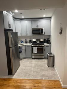 a kitchen with stainless steel appliances and white cabinets at Luxury apartments NY 4 Bedrooms 3 Bathroom Free Parking in Williams Bridge