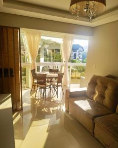 sala de estar con sofá, mesa y sillas en Melhor vista e localização nas Termas en Piratuba