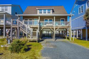 een huis met een veranda en een trap naar de voorkant bij Galleria in Holden Beach