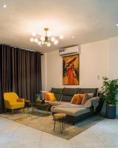 een woonkamer met een bank en een tafel bij The Avery Apartments at Odomaa Place, East Airport in Accra