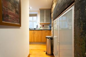 a kitchen with wooden cabinets and a refrigerator at 2 Bedroom Characterful Semi-Detached House, Enviably Located with Balcony and Terrace in St. Andrews