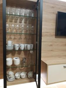 a cabinet with glasses and cups and dishes on it at Modern Apartment, Full Kitchen, for 6 in Gmunden