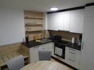 a kitchen with white cabinets and a sink and a table at Modern Apartment, Full Kitchen, for 6 in Gmunden