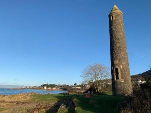 a tall stone tower sitting next to a body of water at Seaview one bedroom apartment in centre of Largs in Largs