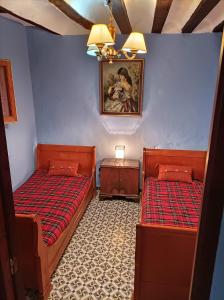 a room with two beds and a picture on the wall at Magnífica casa de pueblo con todas las comodidades in Moratalla