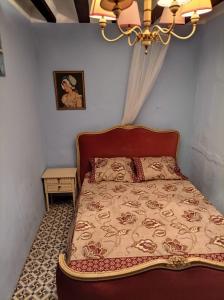 a bedroom with a bed and a chandelier at Magnífica casa de pueblo con todas las comodidades in Moratalla