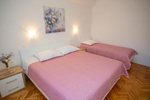 2 letti posti uno accanto all'altro in una stanza di Apartments Tonka a Kustići