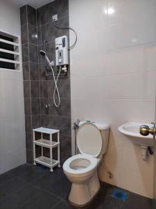ein Bad mit einer Dusche, einem WC und einem Waschbecken in der Unterkunft Yong Guesthouse in Kuala Kangsar