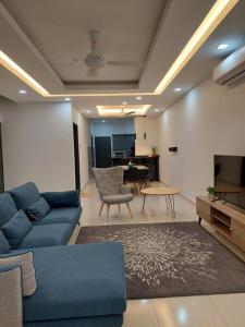 ein Wohnzimmer mit einem blauen Sofa und einem Tisch in der Unterkunft Yong Guesthouse in Kuala Kangsar