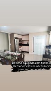 sala de estar con mesa y cocina en Melhor vista e localização nas Termas, en Piratuba