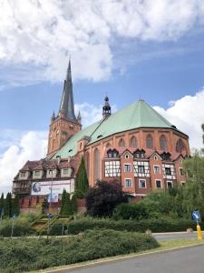 a large brick building with a steeple and a church at Sydonia Apartments - Wyszyńskiego in Szczecin