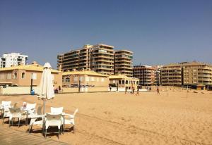 plaża z leżakami, parasolem i budynkami w obiekcie Luxury suite apartment w mieście Torrevieja