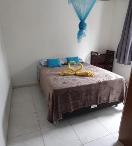 a bedroom with a bed with a pair of gold pretzels on it at Casa Azul Gamboa in Gamboa