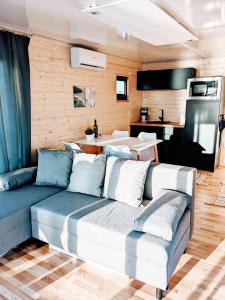 ein Wohnzimmer mit einem Sofa und einer Küche in der Unterkunft Schwimmendes Haus Nico auf dem Wasser inkl Boot in Västervik in Västervik