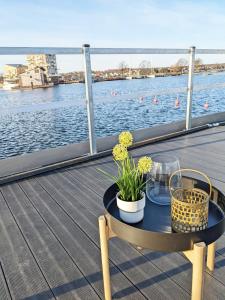 a table on a deck with a view of the water at Schwimmendes Haus Nico auf dem Wasser inkl Boot in Västervik in Västervik