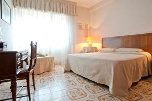 1 dormitorio con 2 camas y ventana grande en Mimì Rooms, en Cagliari
