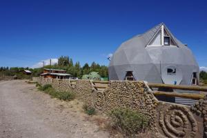 un bâtiment avec un dôme au-dessus d'une clôture en pierre dans l'établissement Domo Lenga, à Chile Chico