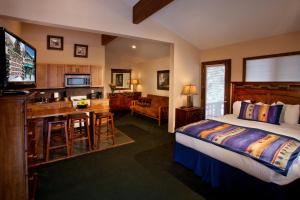 a bedroom with a bed and a kitchen and a living room at Cottam's Lodge by Alpine Village Suites in Taos Ski Valley