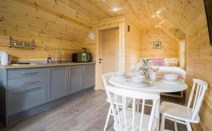 a kitchen and dining room with a table and chairs at Wildflower Meadow Cabins in Whitington