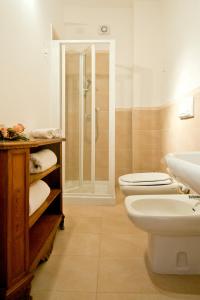 a bathroom with a shower and a toilet and a sink at Mimì Rooms in Cagliari