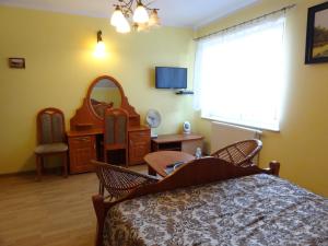 Schlafzimmer mit einem Bett, einem Tisch und einem Spiegel in der Unterkunft Willa Pod Jedlicą in Ciechocinek