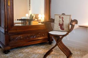 una silla con una almohada sentada frente a un espejo en Mimì Rooms, en Cagliari