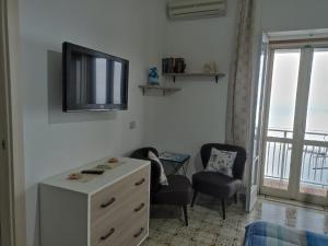 a room with a dresser and a tv on a wall at GIARDINO SUL MARE in Amalfi