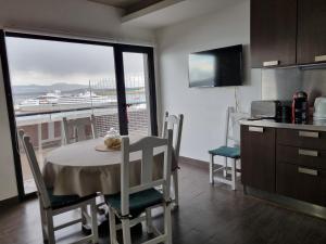 a kitchen with a table and chairs and a balcony at Amaneciendo frente al Beagle in Ushuaia