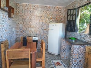 a kitchen with a table and a refrigerator at Casa Repouso da Águia in Mucugê