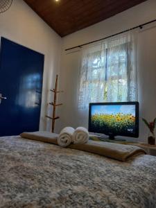 um quarto com uma cama grande e uma televisão de ecrã plano em Edícula Simples, prático e ideal em Ilhabela