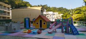 um parque infantil com um escorrega e uma estrutura de jogos em Angra Praia Grande Flat Studio Angra Inn - O Mar de Angra te espera ! em Angra dos Reis