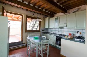 a kitchen with white cabinets and a table with chairs at Casa Torre in Arezzo