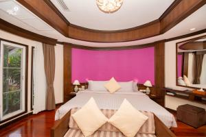 1 dormitorio con 1 cama grande y pared morada en Krabi Resort- SHA Extra Plus, en Ao Nang Beach