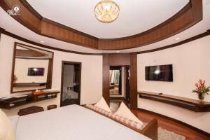 een slaapkamer met een bed en een tv aan de muur bij Krabi Resort- SHA Extra Plus in Ao Nang Beach