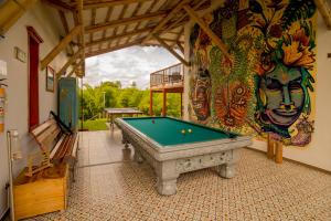 una mesa de billar en una habitación con un mural en Hacienda El Samán, en Quimbaya
