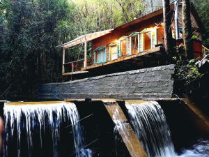 a house in the middle of a waterfall at Casa Molino de Chiloé in Castro