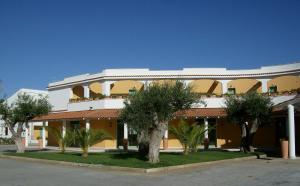 a large white building with trees in front of it at Pitagora Residence in Metaponto