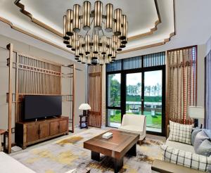 un soggiorno con televisione e lampadario di HUALUXE Suzhou Bay Hot Spring Resort a Suzhou