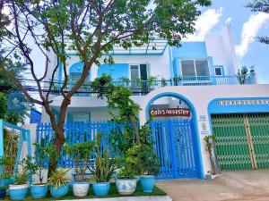 una casa blu e bianca con un cancello blu e piante di Cô Tư's Homestay a Phan Thiet