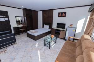 a living room with a couch and a tv at Mix Hotel in Ban Hua Thale