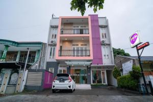 a car parked in a parking lot in front of a building at Sans Hotel FiFFa Pisang Kipas Malang in Malang