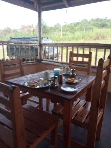 un tavolo in legno con piatti di cibo su un portico di Nguse River Camp a Kikube