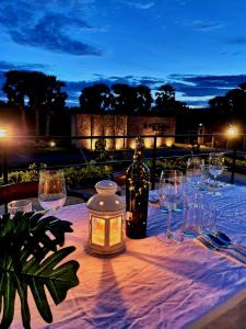 a table with glasses and a bottle and a candle at Kambaniru Beach Hotel and Resort in Waingapu